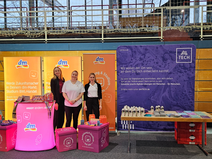 Drei Mitarbeiterinnen stehen am dm und dmTECH-Stand auf der Ausbildungsbörse in Ettlingen.